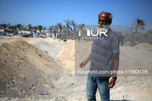 Palestinians inspect the damage at the site of Israeli strikes on a makeshift displacement camp in Mawasi Khan Yunis in the Gaza Strip on Se...