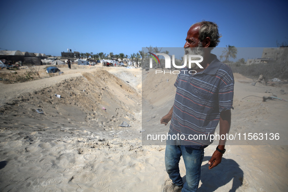 Palestinians inspect the damage at the site of Israeli strikes on a makeshift displacement camp in Mawasi Khan Yunis in the Gaza Strip on Se...