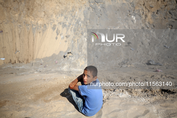 A Palestinian youth inspects the damage at the site of Israeli strikes on a makeshift displacement camp in Mawasi Khan Yunis in the Gaza Str...