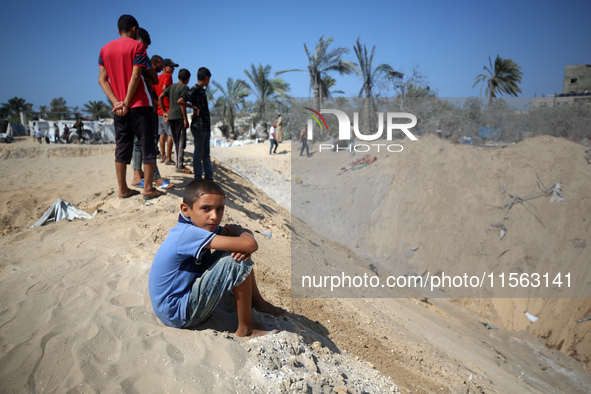 Palestinians inspect the damage at the site of Israeli strikes on a makeshift displacement camp in Mawasi Khan Yunis in the Gaza Strip on Se...