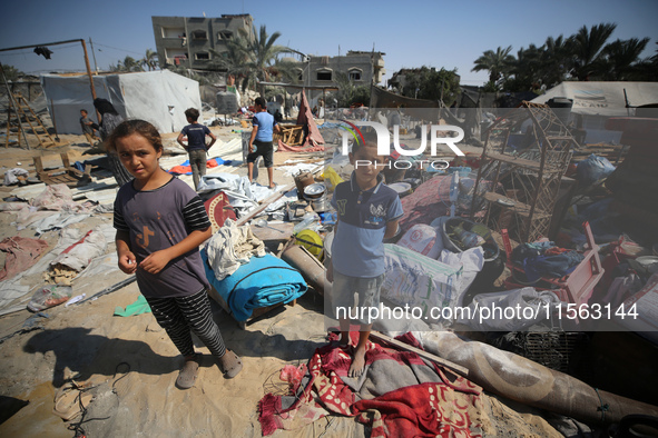 Palestinians inspect the damage at the site of Israeli strikes on a makeshift displacement camp in Mawasi Khan Yunis in the Gaza Strip on Se...