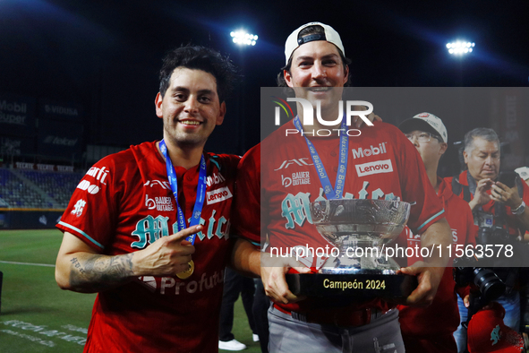 Juan Carlos Gamboa #47 and Trevor Bauer #96 of Diablos Rojos pose with the Zaachila Cup after winning the 2024 Mexican Baseball League (LMB)...