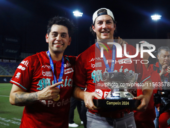 Juan Carlos Gamboa #47 and Trevor Bauer #96 of Diablos Rojos pose with the Zaachila Cup after winning the 2024 Mexican Baseball League (LMB)...