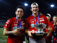 Juan Carlos Gamboa #47 and Trevor Bauer #96 of Diablos Rojos pose with the Zaachila Cup after winning the 2024 Mexican Baseball League (LMB)...