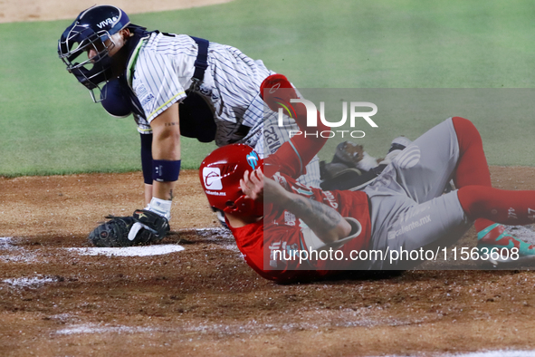 Juan Carlos Gamboa #47 of Diablos Rojos slides to home against Jonathan Morales #27 of Sultanes de Monterrey during the 2024 Mexican Basebal...