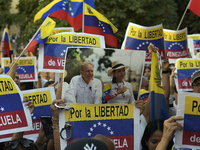 A person holds a picture of Venezuelan opposition presidential candidate Edmundo Gonzalez and Venezuela's opposition leader Maria Corina Mac...