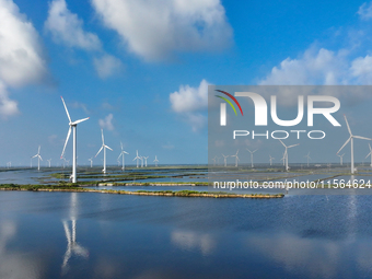 Wind turbines rotate in the wind on the coastal beaches of Yancheng City, Jiangsu Province, China, on September 10, 2024. (