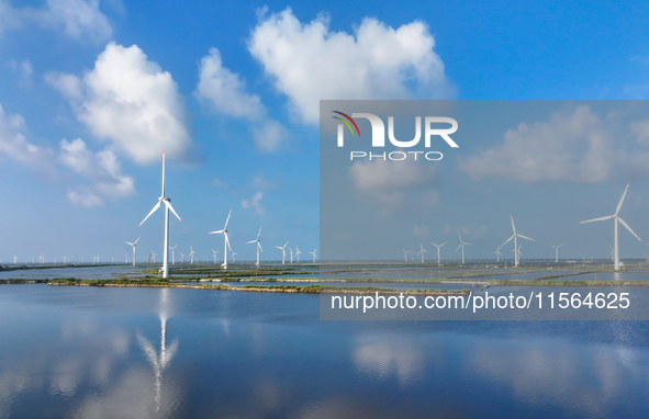 Wind turbines rotate in the wind on the coastal beaches of Yancheng City, Jiangsu Province, China, on September 10, 2024. 