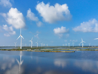 Wind turbines rotate in the wind on the coastal beaches of Yancheng City, Jiangsu Province, China, on September 10, 2024. (