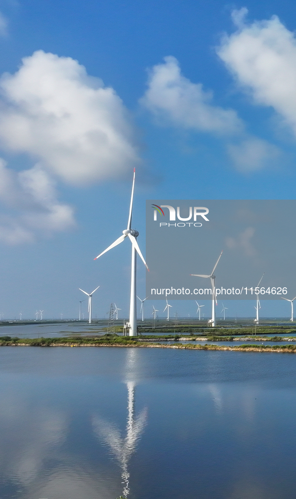 Wind turbines rotate in the wind on the coastal beaches of Yancheng City, Jiangsu Province, China, on September 10, 2024. 