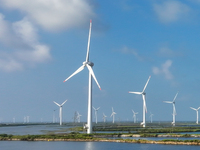 Wind turbines rotate in the wind on the coastal beaches of Yancheng City, Jiangsu Province, China, on September 10, 2024. (