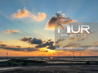 Wind turbines rotate in the wind on the coastal beaches of Yancheng City, Jiangsu Province, China, on September 10, 2024. (