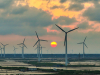 Wind turbines rotate in the wind on the coastal beaches of Yancheng City, Jiangsu Province, China, on September 10, 2024. (