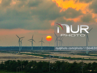 Wind turbines rotate in the wind on the coastal beaches of Yancheng City, Jiangsu Province, China, on September 10, 2024. (