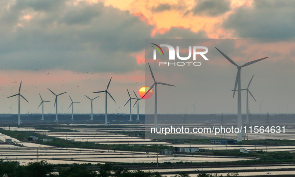 Wind turbines rotate in the wind on the coastal beaches of Yancheng City, Jiangsu Province, China, on September 10, 2024. 