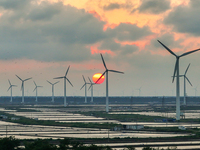 Wind turbines rotate in the wind on the coastal beaches of Yancheng City, Jiangsu Province, China, on September 10, 2024. (