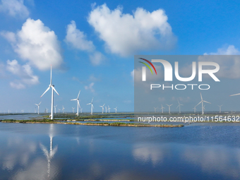 Wind turbines rotate in the wind on the coastal beaches of Yancheng City, Jiangsu Province, China, on September 10, 2024. (