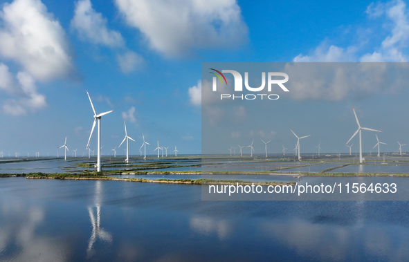 Wind turbines rotate in the wind on the coastal beaches of Yancheng City, Jiangsu Province, China, on September 10, 2024. 