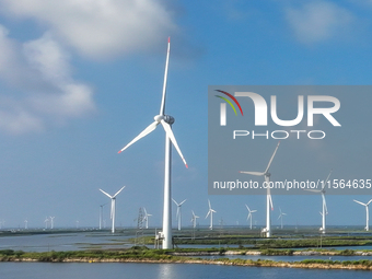 Wind turbines rotate in the wind on the coastal beaches of Yancheng City, Jiangsu Province, China, on September 10, 2024. (