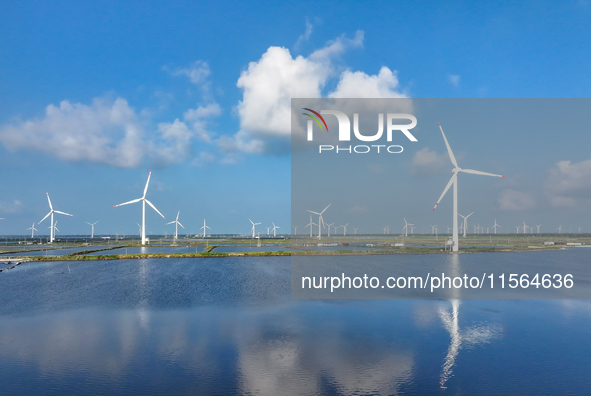 Wind turbines rotate in the wind on the coastal beaches of Yancheng City, Jiangsu Province, China, on September 10, 2024. 