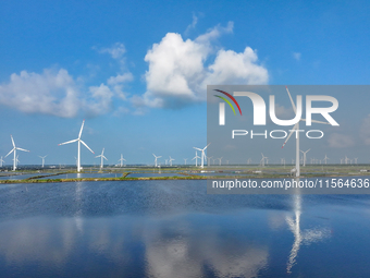 Wind turbines rotate in the wind on the coastal beaches of Yancheng City, Jiangsu Province, China, on September 10, 2024. (