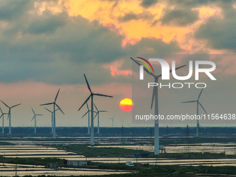 Wind turbines rotate in the wind on the coastal beaches of Yancheng City, Jiangsu Province, China, on September 10, 2024. (