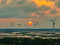 Wind turbines rotate in the wind on the coastal beaches of Yancheng City, Jiangsu Province, China, on September 10, 2024. (