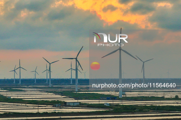 Wind turbines rotate in the wind on the coastal beaches of Yancheng City, Jiangsu Province, China, on September 10, 2024. 