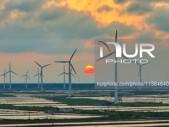 Wind turbines rotate in the wind on the coastal beaches of Yancheng City, Jiangsu Province, China, on September 10, 2024. (