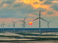 Wind turbines rotate in the wind on the coastal beaches of Yancheng City, Jiangsu Province, China, on September 10, 2024. (