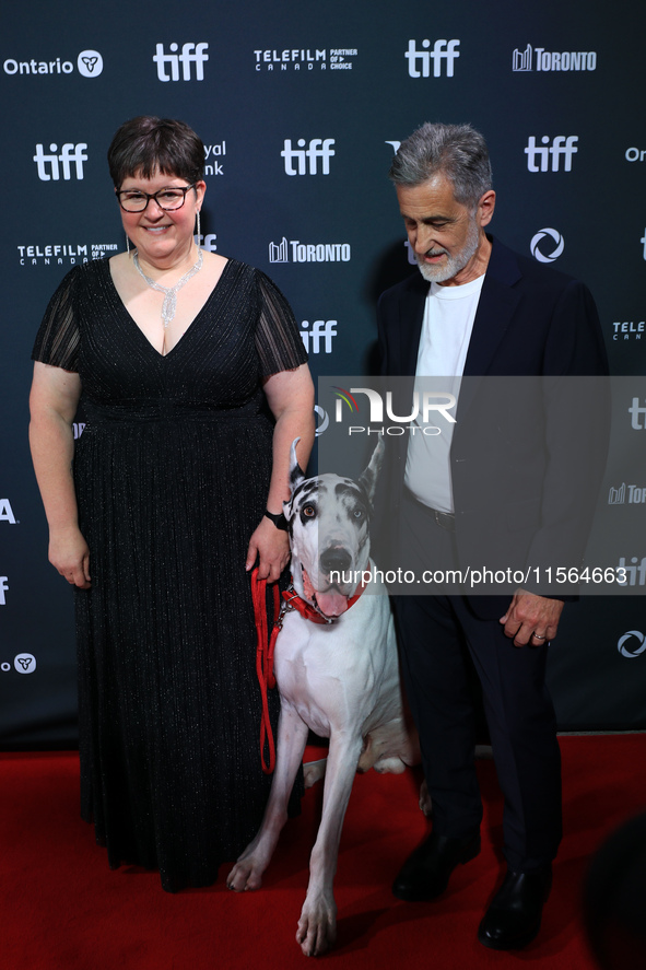 Bev Klingensmith (L) and Bill Berloni (R) pose for a photo with Bing the Dog as they attend the premiere of 'The Friend' during the 2024 Tor...