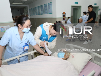 A volunteer in the unaccompanied ward of Shaoxing Central Hospital in Shaoxing, China, on September 10, 2024, waits for a B-ultrasound exami...