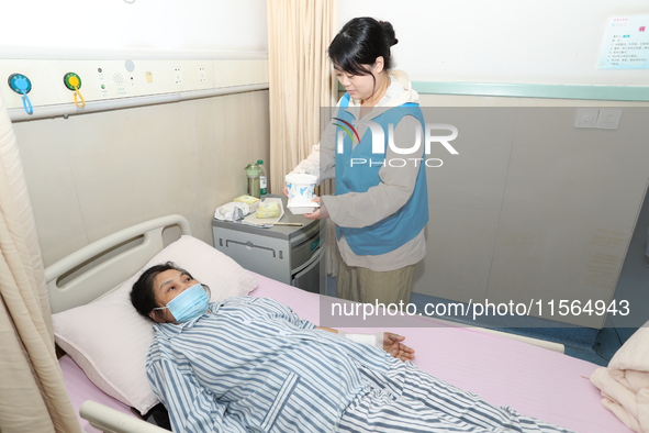 Volunteers in the unaccompanied ward deliver meals to patients at Shaoxing Central Hospital in Shaoxing, China, on September 10, 2024. 