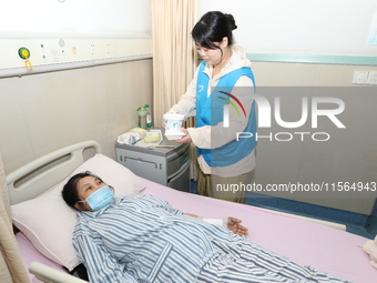 Volunteers in the unaccompanied ward deliver meals to patients at Shaoxing Central Hospital in Shaoxing, China, on September 10, 2024. (