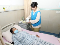 Volunteers in the unaccompanied ward deliver meals to patients at Shaoxing Central Hospital in Shaoxing, China, on September 10, 2024. (