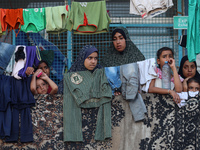 Displaced Palestinians take shelter at a UN school and watch after an Israeli air strike hits the site in Nuseirat, Gaza Strip, on September...