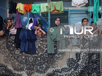 Displaced Palestinians take shelter at a UN school and watch after an Israeli air strike hits the site in Nuseirat, Gaza Strip, on September...