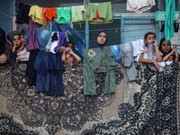 Displaced Palestinians take shelter at a UN school and watch after an Israeli air strike hits the site in Nuseirat, Gaza Strip, on September...