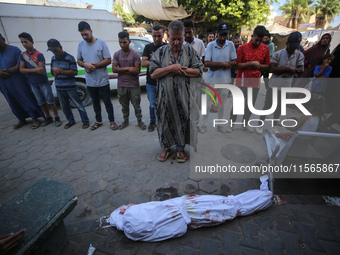 People perform a funeral prayer near the body of 6-year-old Palestinian girl Fatmah Juma, who is killed by an Israeli airstrike that hits th...