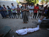 People perform a funeral prayer near the body of 6-year-old Palestinian girl Fatmah Juma, who is killed by an Israeli airstrike that hits th...