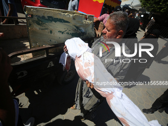 People perform a funeral prayer near the body of 6-year-old Palestinian girl Fatmah Juma, who is killed by an Israeli airstrike that hits th...