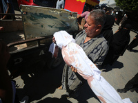 People perform a funeral prayer near the body of 6-year-old Palestinian girl Fatmah Juma, who is killed by an Israeli airstrike that hits th...