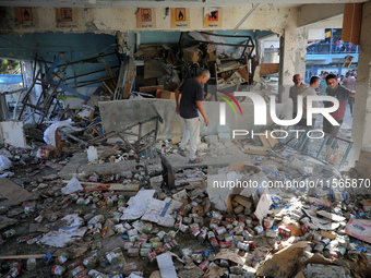 Palestinians check the grounds of a school after an Israeli air strike hits the site in Nuseirat, Gaza Strip, on September 11, 2024, amid th...