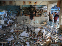 Palestinians check the grounds of a school after an Israeli air strike hits the site in Nuseirat, Gaza Strip, on September 11, 2024, amid th...