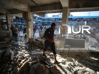 Palestinians check the grounds of a school after an Israeli air strike hits the site in Nuseirat, Gaza Strip, on September 11, 2024, amid th...