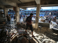 Palestinians check the grounds of a school after an Israeli air strike hits the site in Nuseirat, Gaza Strip, on September 11, 2024, amid th...