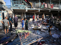 Palestinians check the grounds of a school after an Israeli air strike hits the site in Nuseirat, Gaza Strip, on September 11, 2024, amid th...