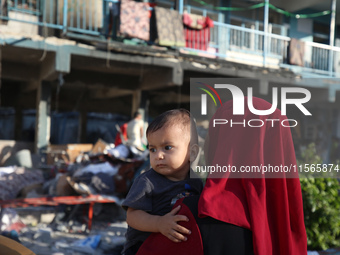 Palestinians check the grounds of a school after an Israeli air strike hits the site in Nuseirat, Gaza Strip, on September 11, 2024, amid th...