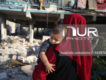 Palestinians check the grounds of a school after an Israeli air strike hits the site in Nuseirat, Gaza Strip, on September 11, 2024, amid th...