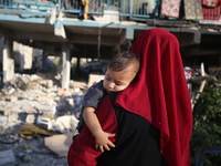 Palestinians check the grounds of a school after an Israeli air strike hits the site in Nuseirat, Gaza Strip, on September 11, 2024, amid th...